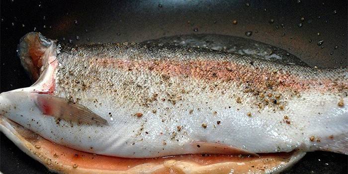 Цветная форель жарится на сковородке