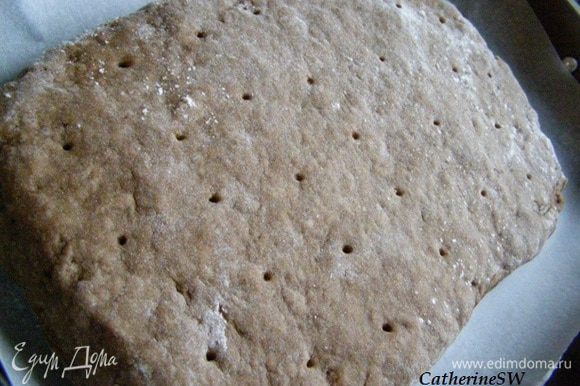 Переложим на лист, покрытый пергаментом, Сделаем проколы зубочисткой, верх смажем молоком.